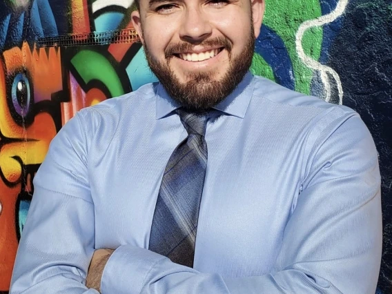 Image of Carlos Parra in front of a mural