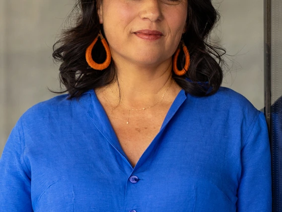Professor Téllez in blue jumpsuit, looking at camera.