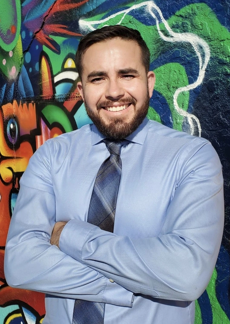 Image of Carlos Parra in front of a mural