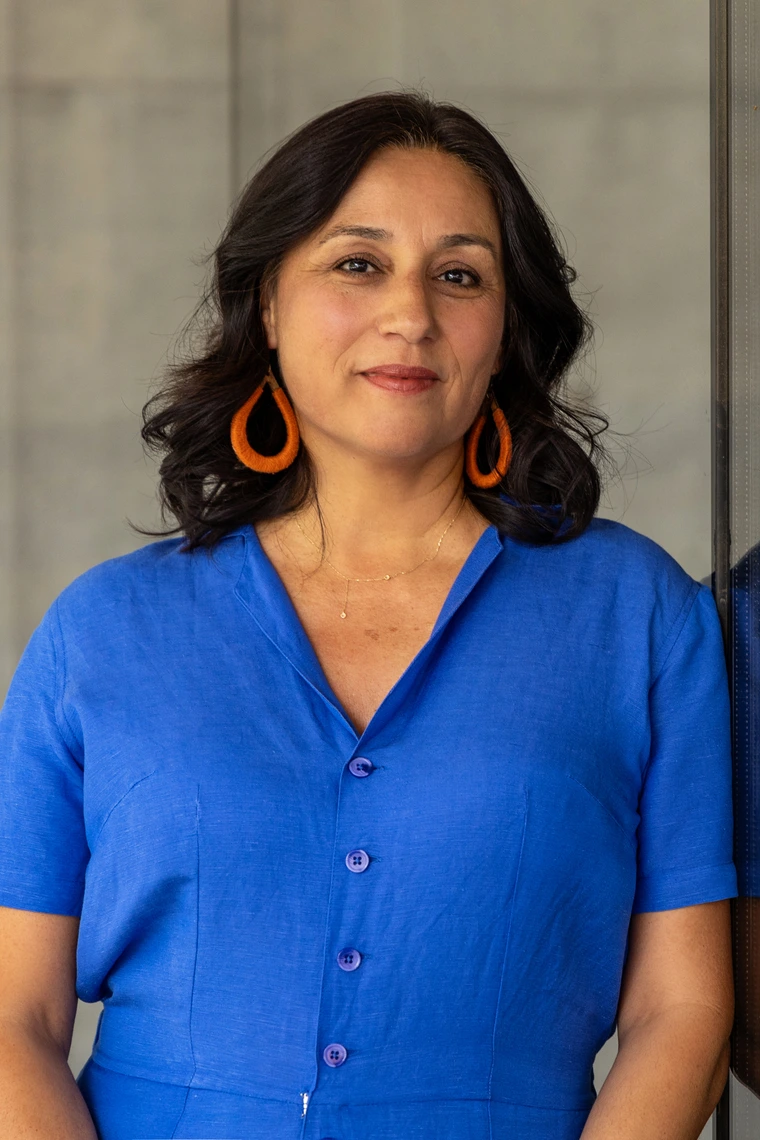 Professor Téllez in blue jumpsuit, looking at camera.